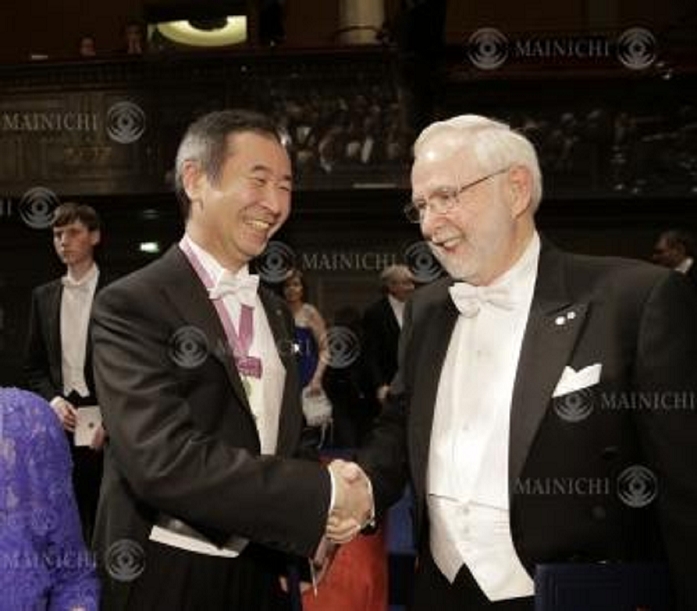 Nobel Prize 2015. Award ceremony in Stockholm Takaaki Kajita, director of the Institute for Cosmic Ray Research at the University of Tokyo, shakes hands with Professor Emeritus Arthur Macdonald  right  of Queen s University, Canada, who shared the physics prize, after the Nobel Prize ceremony, at the Concert Hall in Stockholm, December 10, 2015, 5:44 PM  photo by representative .