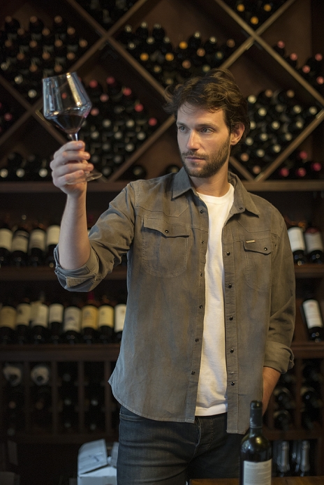 Wine connoisseur holding up glass of wine