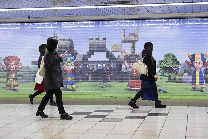 Massive Monster Attack in Shinjuku  Unblock and defeat them  Pedestrians walk past a giant Dragon Quest poster after fans have collected the 180,000 Lego blocks from the wall mural on January 28, 2016, Tokyo, Japan. The mural was a part of a promotion in Shinjuku Station to celebrate the release of new game Dragon Quest Builders. The 80 meter mural was made with 180,000 Lego blocks and fans were allowed to remove blocks to reveal the poster behind. Some blocks contained QR codes allowing fans to access exclusive content.  Photo by Rodrigo Reyes Marin AFLO 