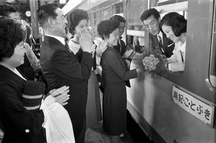 Honeymoon  October 3, 1965  Dating 1965. Japan National Railways Tennoji Station, where the first newlywed only train  Kotobuki go  departs this fall. A newlywed couple is embarrassed as their family and friends see them off. 1965.10.03 Photographed: Japan National Railways Tennoji Station, where the first newlywed only train  Kotobuki go  departs this fall. A newlywed couple is embarrassed as their family and friends see them off at Tennoji Station of Japan National Railways  JNR  in Tennoji Ward, Osaka City, October 3, 1965  photo by Eiichiro Katayama.