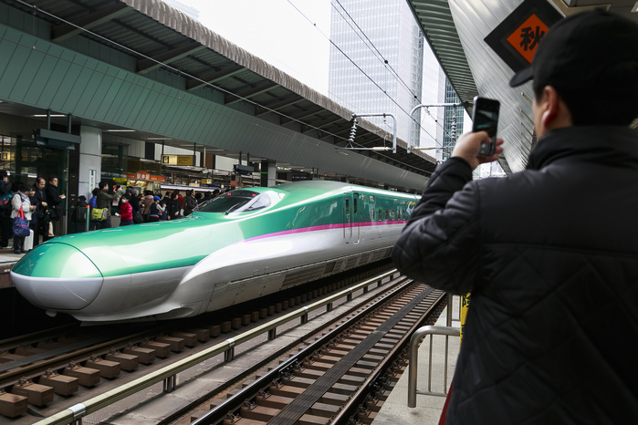 Hokkaido Shinkansen Line Opens Tokyo   Shin Hakodate Hokuto in 4 hours A man takes a picture of the Hayabusa Shinkansen  bullet train  in Tokyo Station on March 26, 2016, Tokyo, Japan. The Hayabusa shinkansen connects Tokyo with the northern island of Hokkaido via the 53.85 km long Seikan Tunnel. Previously Japan s bullet train only operated as far as Aomori but the new rail link now goes to Shin Hakodate Hokuto Station in Hokkaido with a further extension planned to Sapporo by 2030. A one way ticket costs 22,690 yen  200 UDS  from Tokyo to Shin Hakodate Hokuto and the fastest trains will take 4 hours and 2 minutes for the journey.  Photo by Rodrigo Reyes Marin AFLO 