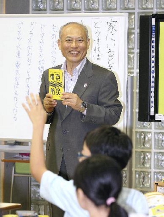 Governor Masuzoe of Tokyo Metropolitan Government talking to children with the disaster prevention book  Tokyo Disaster Prevention  in hand. Tokyo Governor Yoichi Masuzoe speaks to children with a copy of  Tokyo Disaster Prevention,  a disaster prevention book that the Tokyo Metropolitan Government has begun distributing to all households in Tokyo. At Konan Elementary School in Minato Ward, Tokyo, Sept. 24, 2015.