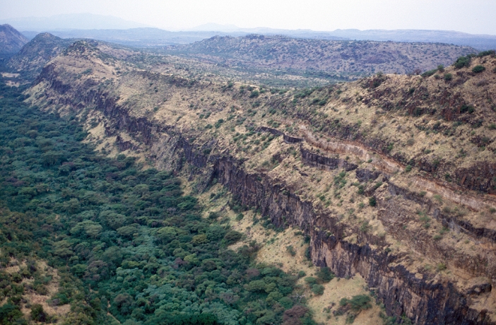 Kenya Great Rift Valley  Date of shooting unknown  Great Rift Valley landscape, Kenya, aerial photograph. The Great Rift Valley has been formed by seismic forces as the Earth s tectonic plates move apart in this area. This has created the large cliffs seen here, in which layers of sedimentary rock are seen. The Great Rift Valley extends for thousands of kilometres north to south through eastern Africa, from Ethiopia to Mozambique.