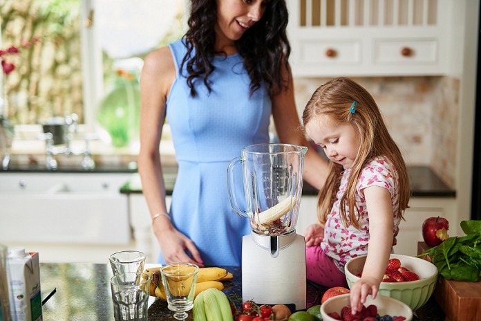 Mother and daughter making smoothies