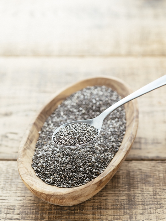 Chia seeds in a wooden bowl with spoon