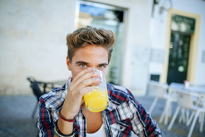 Young man drinking an orangeade