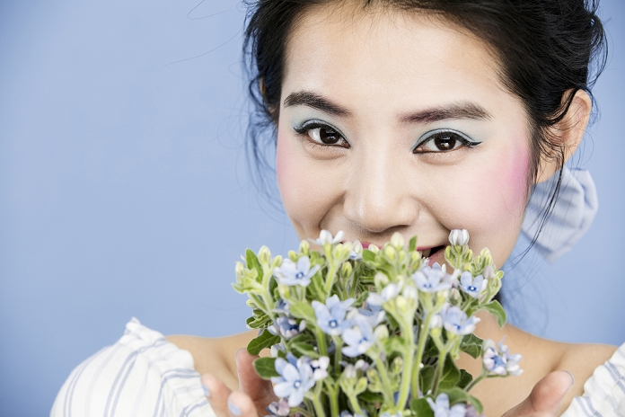 Portrait of young smiling woman with wild flowers