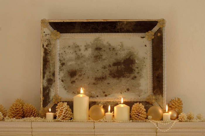 WESTF01069 Burning candles with fir cones and frame on shelf , close up