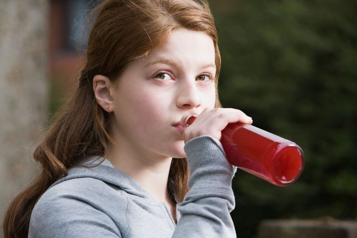 A teenage girl drinking alcopops