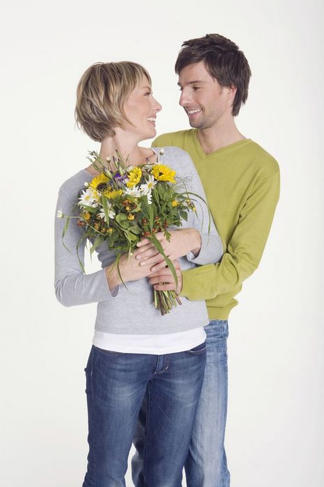 WESTF06872 Young man giving young woman bunch of flowers, portrait