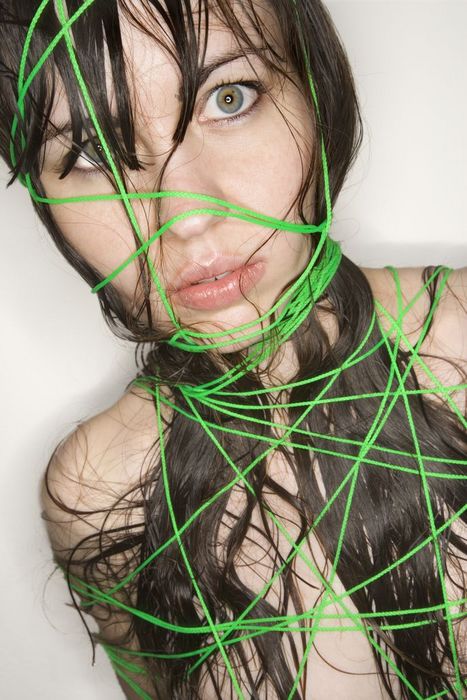 Nude Caucasian young adult woman wrapped in string.