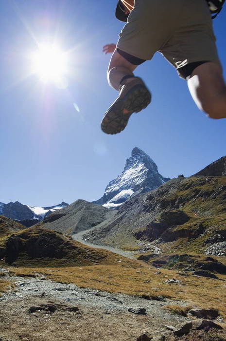 Men doing a trail run Hiker running on trail and the Matterhorn, 4477m,  Zermatt Alpine Resort, The Valais, Swiss Alps, Switzerland, Europe