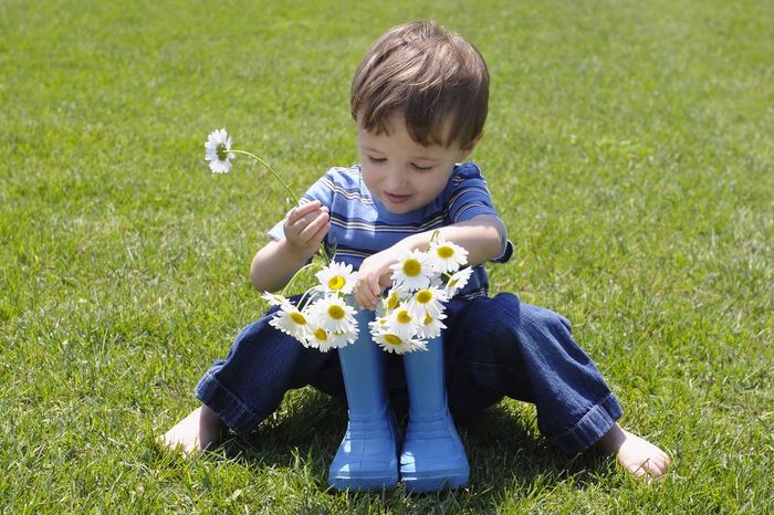 Little Boy placing Flowers into Rubber Boots