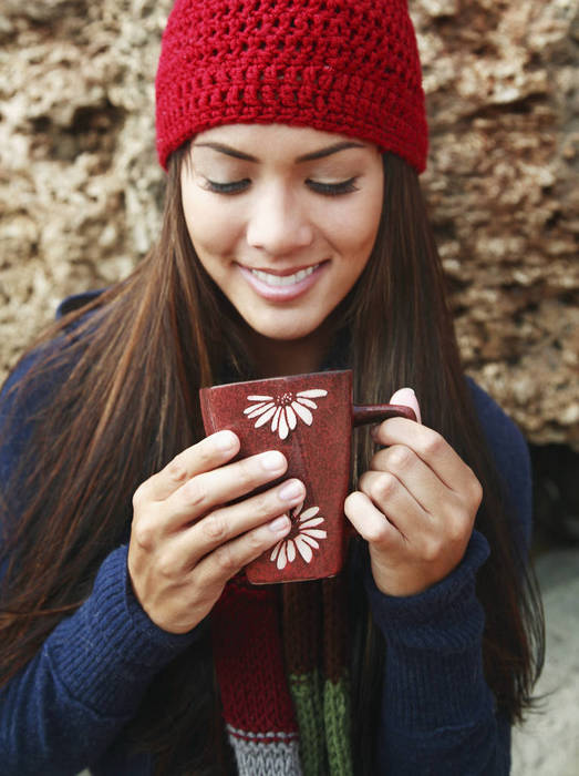 Hawaii, Oahu, Young woman outside in cozy winter weather drinking coffee.