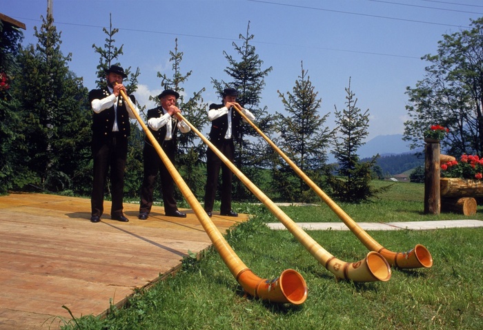 Switzerland Yodel Festival Three men blow alpine horns at the Alphorn and Yodle Festival in Switzerland