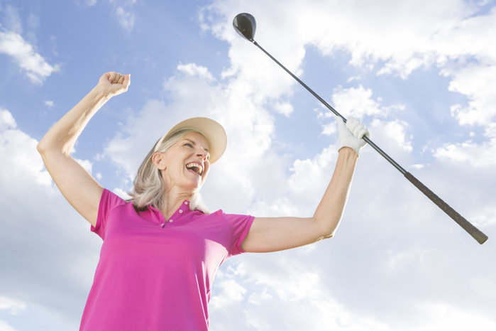 Senior woman playing golf Caucasian woman celebrating with golf club
