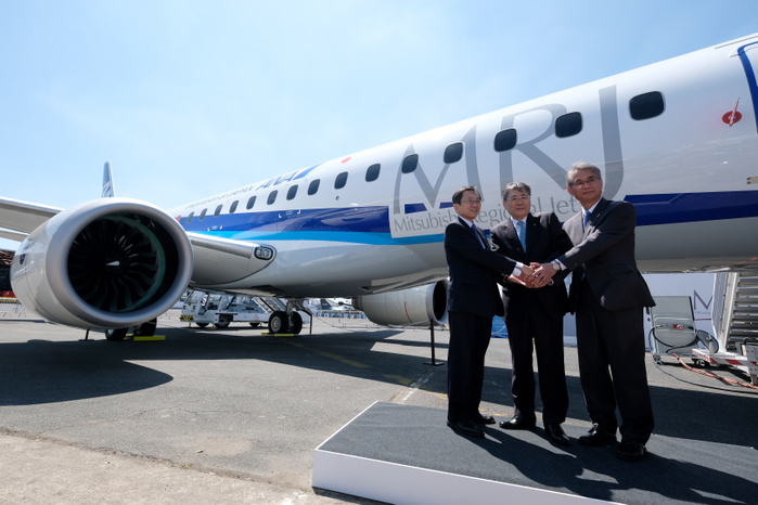 2017 Paris Air Show Hisakazu Mizutani  right , Mitsubishi Aircraft Corporation s president, Shunichi Miyanaga  center , Mitsubishi Heavy Industries  President and Chief Executive Officer, and Osamu Shinobe, ANA Holdings Inc. s Vice Chairman, shake hands in front of the third Flight Test Aircraft  FTA 3  of Mitsubishi Regional Jet  MRJ  at the Le Bourget Airport, a day before the opening of the 2017 Paris Air Show on June18, 2017, in Paris, France.  Photo by Yuriko Nakao AFLO 