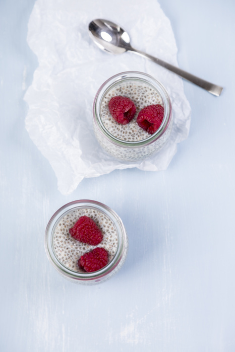 Glass of chia pudding with soya vanilla milk and raspberries