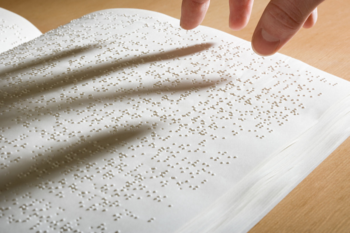 Fingers above a braille book Fingers above a braille book