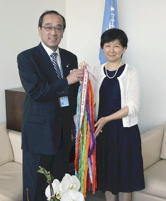 A bomb survivors and others attend Nuclear Weapons Convention negotiating session Mayor Matsui presents an origami crane to Mr. Nakamitsu  right  on the afternoon of April 14 at the United Nations Headquarters in New York, U.S.A.  representative photo .