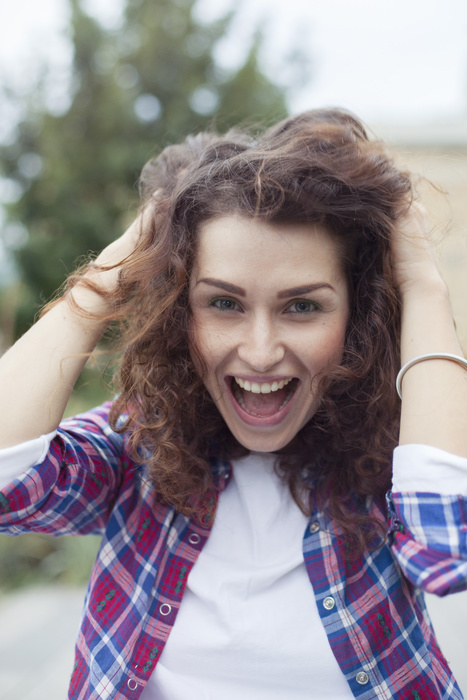 female Carefree young woman laughing outdoors, portrait