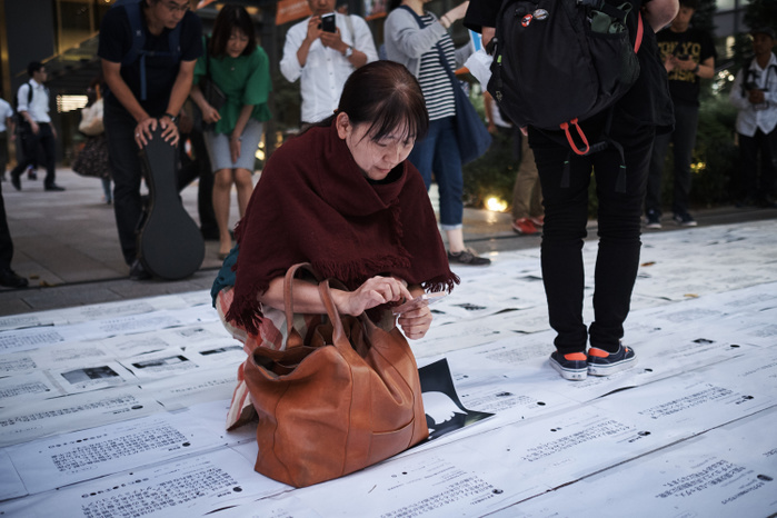 Twitter anti hate speech demonstration September 8, 2017: A pedestrian takes a picture of printed tweet. Anti racism movement gathers for demonstration in front of Twitter Japan in Tokyo, Japan, 8 September 2017. Right wing, far right wing uses twitter for racism tweet, discrimination and hate speech against mostly chinese and korean people.  Photo by Nicolas Datiche AFLO   JAPAN 