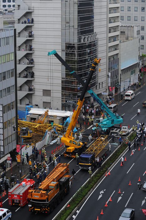 Construction crane collapses A part of a collapsed crane is hoisted onto the bed of a truck at a construction site in the middle of Tokyo Tuesday afternoon, April 14, 2009. Six people were reported injured, including two seriously, when the crane collapsed, smashing a truck running in the nearby street.  1080 