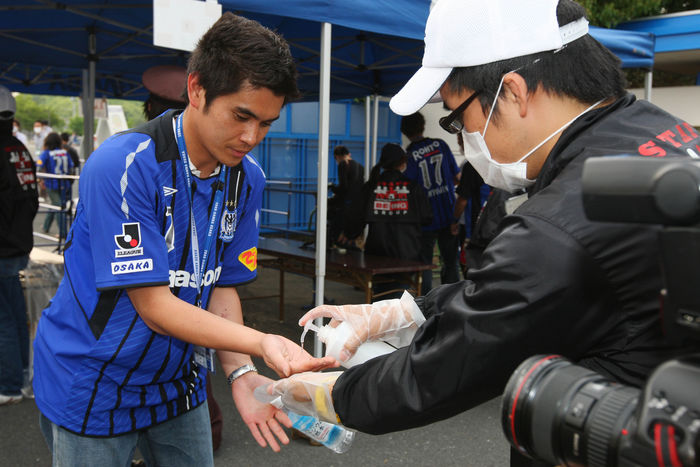 Japanese soccer fans have their hands disinfected before entering a stadium in Osaka, western Japan, for an AFC Champions League match South Korean team edged Japan in a 2-1 narrow victory in Group F. (Photo by AFLO SPORT) [1045].