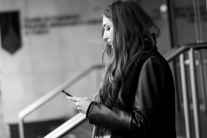 A woman looking at her smartphone Serious Caucasian woman texting on cell phone