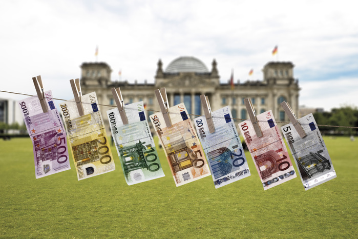 Germany, Berlin, Euro bank notes hanging on clothesline, Reichstag building in background