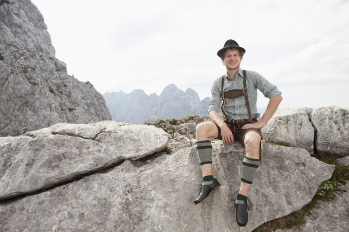 Germany, Bavaria, Osterfelderkopf, man in traditional clothes sitting in mountain landscape