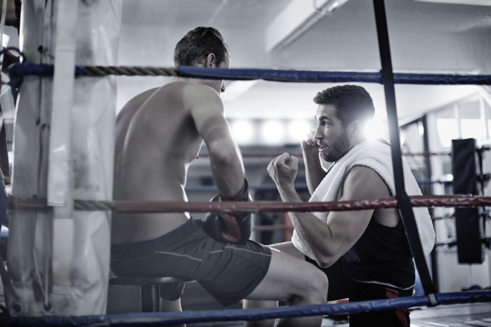 boxing Boxer having a break with trainer in the corner of the boxing ring