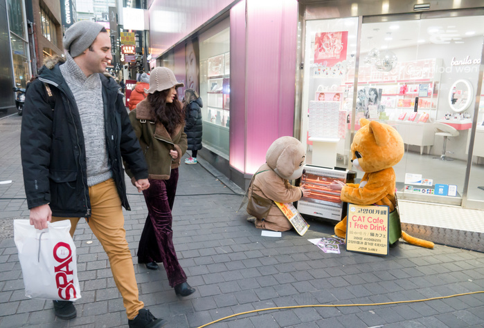 Part time workers promoting pet cafes get warm by an electric heater of a cosmetics store on Myeongdong shopping street in Seoul Korean weather, Jan 23, 2018 : Part time workers promoting pet cafes get warm by an electric heater of a cosmetics store on Myeongdong shopping street in Seoul, South Korea. An extreme cold wave hit the country on Tuesday with lows of minus 13 degrees Celsius and with wind chill temperature of minus 20.1 C in Seoul, according to the Korean Meteorological Administration.  Photo by Lee Jae Won AFLO   SOUTH KOREA 
