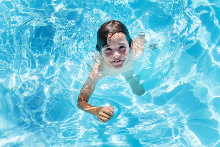 boy Overhead portrait of boy treading water in outdoor sunlit swimming pool