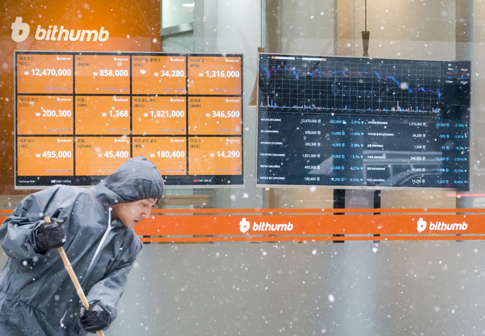 A man sweeps snow with a broom in front of an electronic signboard of a cryptocurrency exchange in Seoul Cryptocurrency, Jan 30, 2018 : A man sweeps snow with a broom in front of an electronic signboard of a cryptocurrency exchange in Seoul, South Korea. South Korea launched a real name trading system for cryptocurrencies on Jan 30, 2018, to prevent virtual coins from being used for money laundering and other illegal activities, local media reported.  Photo by Lee Jae Won AFLO   SOUTH KOREA 