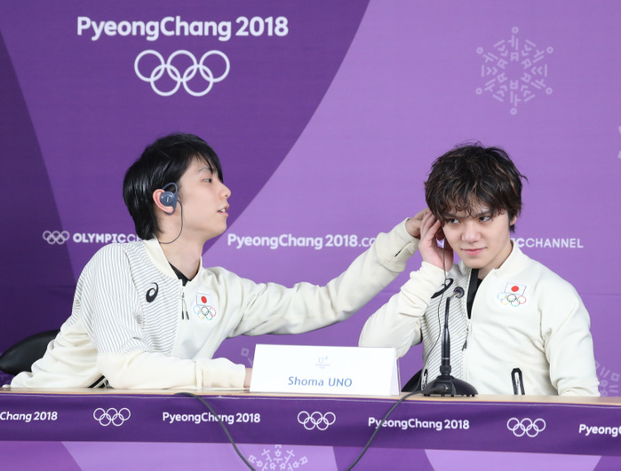 2018 PyeongChang Olympics Figure Men SP Press Conference Yuzuru Hanyu helps Masama Uno  right  put on translation headphones during the press conference after the men s SP figure skating at the PyeongChang Olympics, Feb. 16, 2018  photo date 20180216  photo location  Gangneung Ice Arena