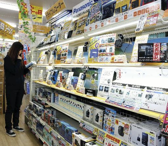 shuffling  one s feet  A customer selects a drive recorder at Yellow Hat Yamagata Chuo store in Minamihara machi, Yamagata City at 8:05 p.m. on Nov. 15. Various types of drive recorders are lined up on the sales floor at the Yellow Hat Yamagata Chuo store in Minamihara machi, Yamagata City on November 15, 2017.
