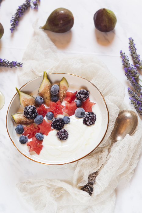 frozen yogurt Bowl of Greek yoghurt with fig, watermelon, frozen berries and lavender honey