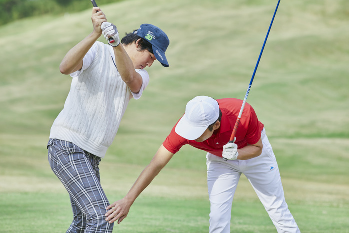 Japanese man taking a golf lesson.