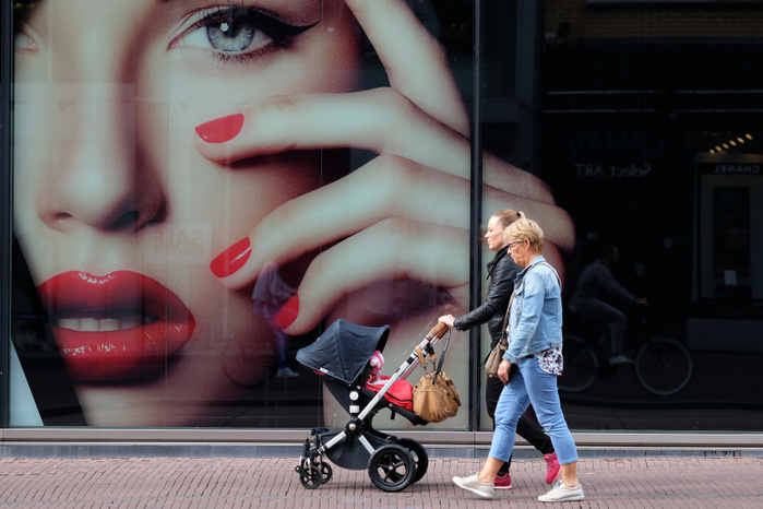Utrecht, The Netherlands A woman pushing a stroller walks with an elderly woman in front of an advertisement with a female model outside a department store in Utrecht, Netherlands, August 18, 2017.  Photo by Yuriko Nakao AFLO   