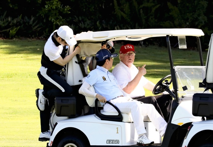 Prime Minister Abe visits the U.S. to play golf with President Trump  photo provided by Cabinet Public Relations Office  Prime Minister Abe and U.S. President Trump  right  talk while riding in a golf cart on April 18 in Palm Beach, Fla. Courtesy of the Cabinet Public Relations Office