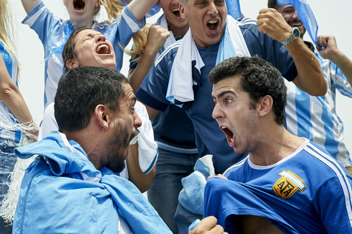 Shouting sports fans Argentinian football fans cheering while watching football match