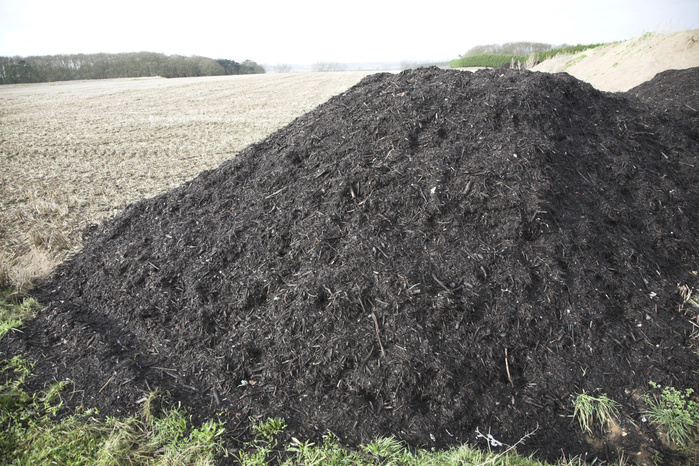 Pile of organic compost manure fertiliser by arable field, Sutton, Suffolk, England