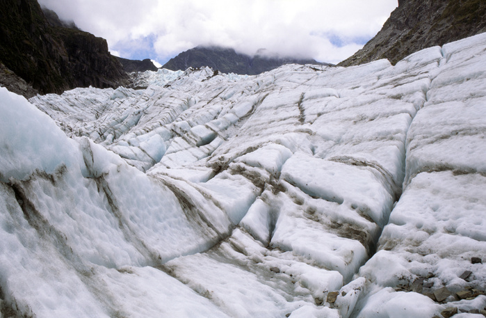 Glacial ice embedded with moraine sediment transported by Fox glacier, New Zealand