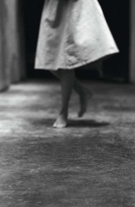 Woman walking barefoot on concrete, lower section, b&w