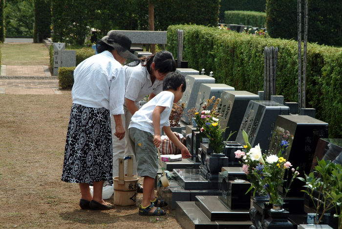 Obon Grave Visits  August 13, 2004   Japan:August 13, 2004Today is the first day of Bon festival  ancestor  39 s soul comes back to this world.  All families visit the cemetary for worship.  Cleaning the tomb and give it the beautiful flowers.  Bon festival is the biggest summer event in Japan and Bon holiday is bigger than new year holiday in Japan.  This cemetary is public cemetary in Chiba, near Tokyo. One of the biggest ones.Bon is in hottest season in Japan, and big summer holiday.photo by Kaku Kurita, Tokyo Gamma Photo by Fujifotos AFLO   3618 