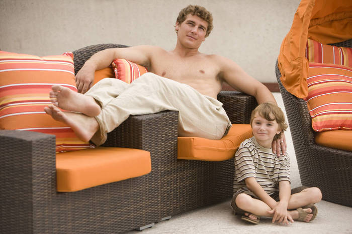 Family portrait of father and son lounging on rooftop terrace