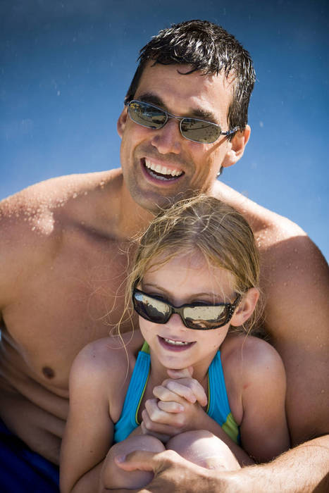 Close up portrait of father and daughter in swimsuits wearing sunglasses