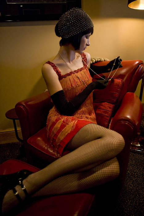 Portrait of woman in flapper dress lounging in armchair in the 1920s
