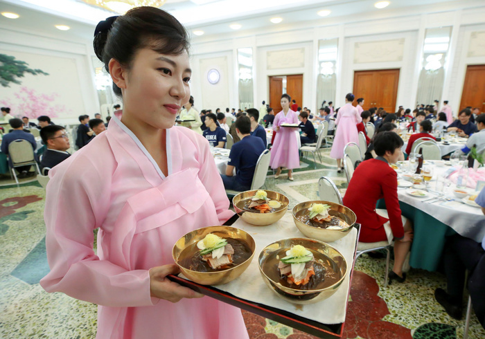 North Korean employees serve cold noodles or Naengmyeon as basketball players from South Korea and North Korea attend a banquet welcoming South Korean delegation at Okryukwan Restaurant in Pyongyang Inter Korean friendly basketball match, July 3, 2018 : North Korean employees serve cold noodles or Naengmyeon as basketball players from South Korea and North Korea attend a banquet welcoming South Korean delegation at Okryukwan Restaurant in Pyongyang, North Korea. The 100 strong South Korean delegation of athletes, coaches, government officials and journalists arrived in Pyongyang on Tuesday. South and North Korea will hold four inter Korean friendly basketball matches in Pyongyang from July 4 5. The inter Korean basketball matches will be held for the first time in 15 years. EDITORIAL USE ONLY  Photo by Press Pool in Pyeongyang Lee Jae Won AFLO   NORTH KOREA 